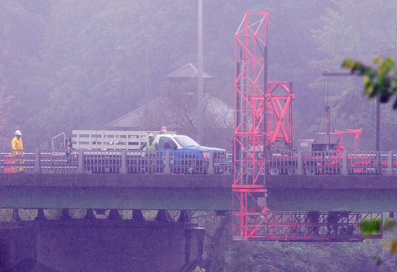 Construction workers under and on the Calumet Bridge at Old Fort Western work on natural gas pipe line on a rainy Friday over the Kennebec River in Augusta. More than an inch of rain fell at the Augusta State Airport on Friday, according to the National Weather Service.