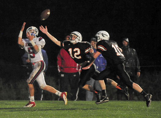 Messalonskee's Devin Warren, 5, makes a touchdown reception over Skowheganl defenders Owen Mercier, 12, and Adam Clukey in the first quarter Friday night in Skowhegan. The Indians won the game 14-6.