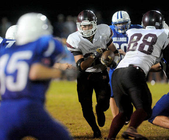 Nokomis High School's Noah Kershner, center, hits a hole in the line against Madison High School at Madison High School on Friday.
