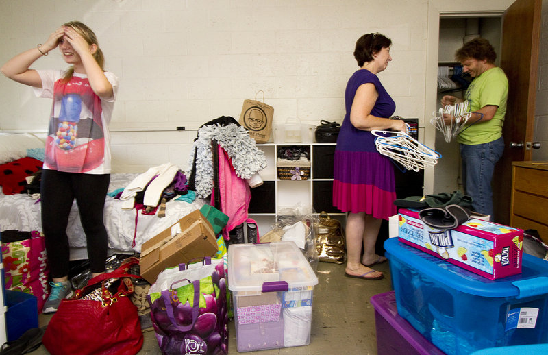 Freshman Georgia Thompson of Bennington, Vt., seems overwhelmed momentarily, while moving into Woodward Hall at the University of Southern Maine in Gorham with the help of her parents, Annette and Jeff Thompson, on Sunday.
