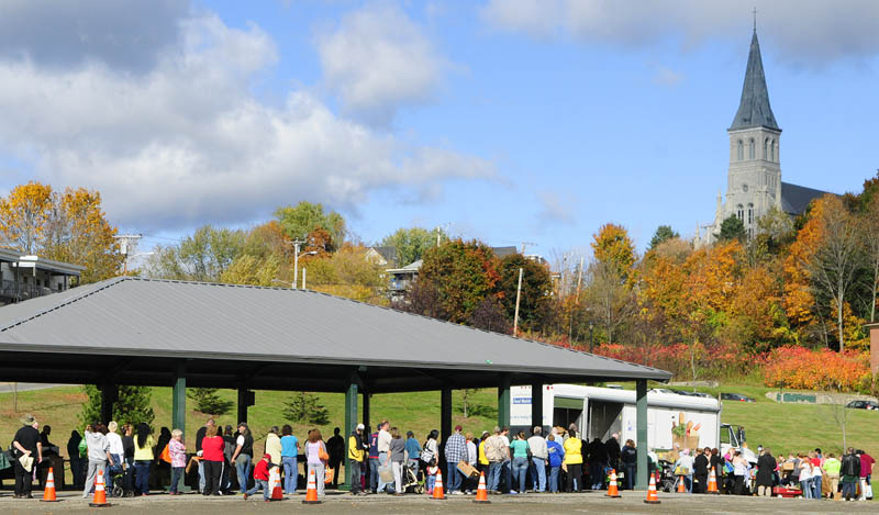 Hundreds of people stand in line during a Good Shepherd Food Bank food mobile event on Friday at Mill Park in Augusta.