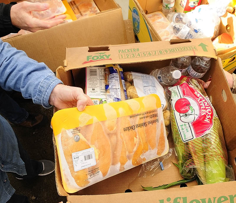 Volunteers hand out food during a Good Shepherd Food Bank food mobile event on Friday at Mill Park in Augusta.