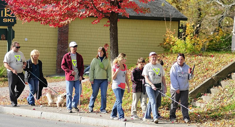 During a walk held to raise awareness of white canes and guide dogs today along Bangor Street in Augusta.