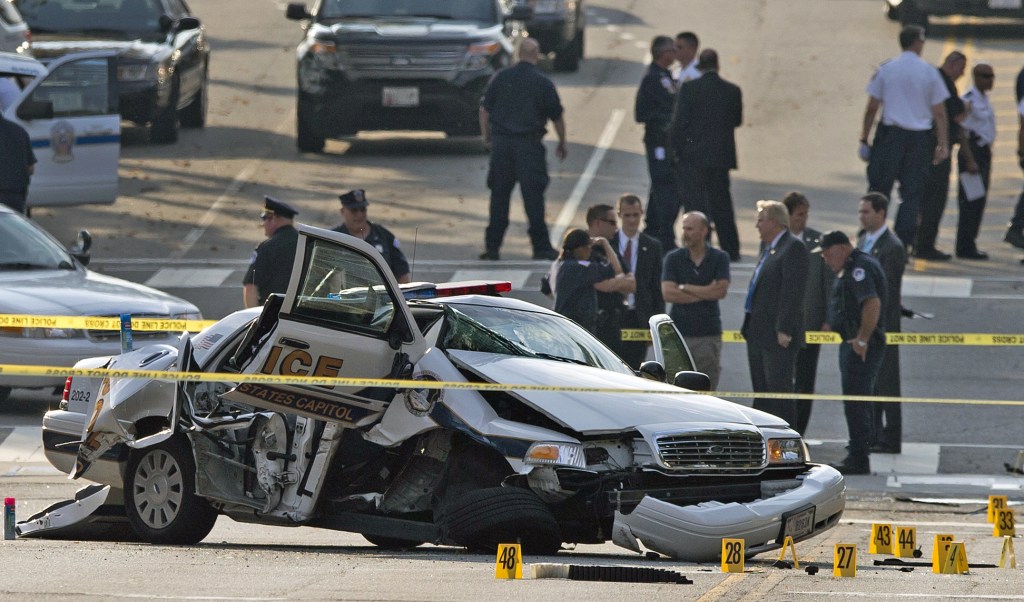 A damaged Capitol Hill police care is surrounded by crime scene tape after a car chase and shooting on Capitol Hill in Washington, Thursday, Oct. 3, 2013. A woman driving a black Infiniti with a young child inside tried to ram through a White House barricade Thursday, then led police on a chase that ended in gunfire outside the Capitol, witnesses and officials said.