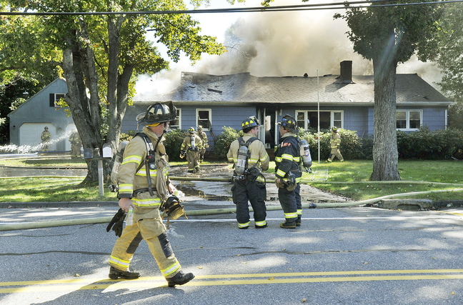 Firefighters extinguish a blaze at a home on Park Road in Westbrook on Tuesday. The fire started in a generator that had been turned on after a nearby car accident knocked out power.
