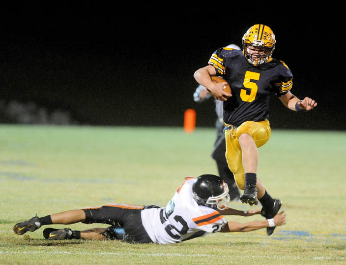 UP AND OVER: Mt. Blue High School’s Jacob Williams (5) leaps over Gardiner’s Tyler Caron during the Cougars’ 41-0 win Friday at Mt. Blue High School.