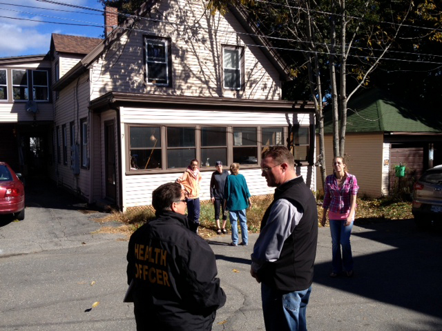 Augusta health officer Raenae Moore and code enforcement officer Rob Overton confer Tuesday outside of 7 Waldo St. after a morning fire in the apartment building.