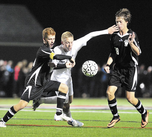 MOVE OVER: Hall-Dale’s Nat Crocker, middle, tries to slip between St. Dominic defenders Ryan Lutrzykowski, left, and Calvin Stewart on Friday at Thomas College in Waterville