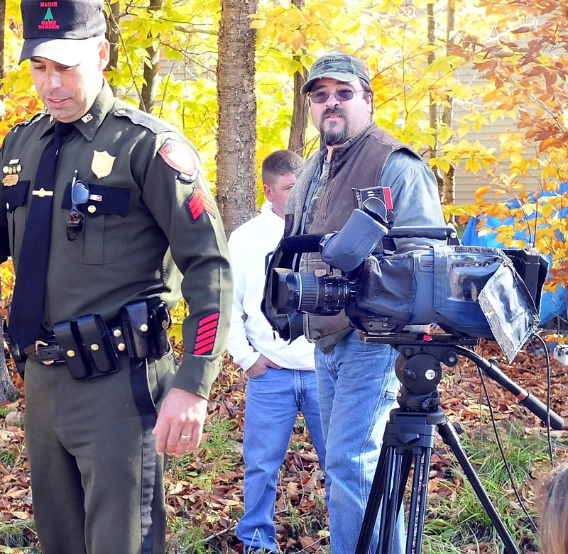 Game Warden Terry Hughes walks by as Dave Stevens watches the scene unfold as police searched for missing toddler Ayla Reynolds near his property on Nike Lane in Oakland on Wednesday. Stevens said he hopes they find the girl alive.