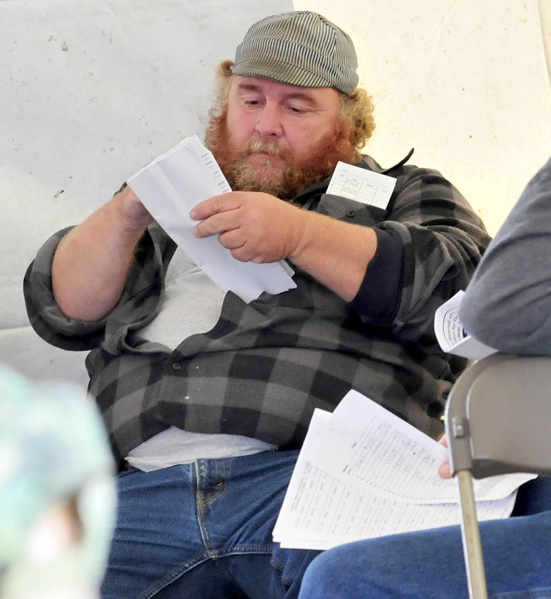 Dairy cow buyer Unc Brock keeps track of his purchases during an auction at the Egide Dostie Dairy Farm in Fairfield on Wednesday.