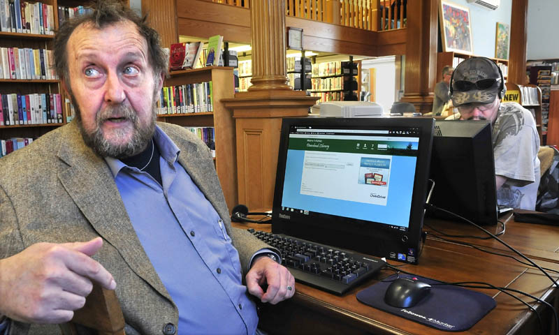 Wilton Public Library Director David Olson explains the use of the Maine InfoNet Download Library website for patrons to access e-books. William Denyou works on another computer at right.