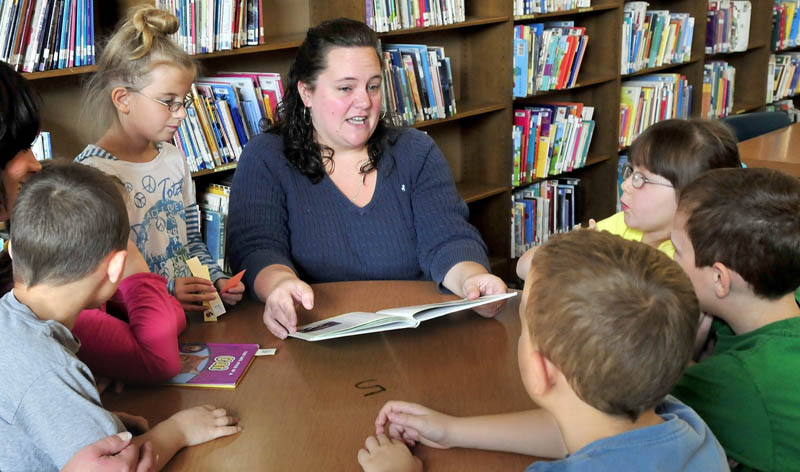Volunteer Haley Ker reads to second graders at the George Mitchell School in Waterville on Thursday. Ker is among several who donate their time and talent at the school.