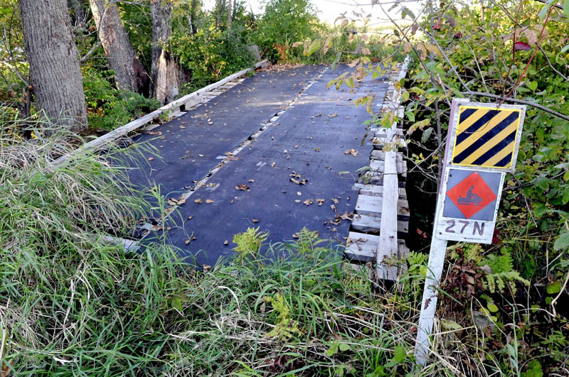 Staff photo by David Leaming MAINTENCE: The snowmobile bridge on ITS 27 in Madison is in need of repair after a tree toppled on it recently. Abnaki Sno-Riders club members are seeking more volunteers to help maintain area trails.
