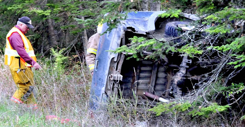 Unity firefighters survey a pickup truck that rolled over after colliding with a Chevrolet Cavalier on Route 139 in Unity Township on Monday.