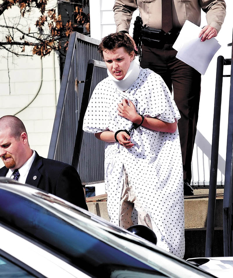 Wearing a hospital gown and neck brace from injuries sustained earlier on Tuesday, suspect Zachary Wittke exits the Franklin County District Court in Farmington following a hearing on charges of eluding police, passing a roadblock and aggravated criminal mischief.