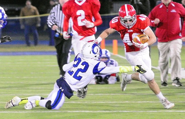 BIG PLAY: Cony wide receiver Jonathan Saban stiff arms Kennebunk defensive back Larson Coppinger while running after catching a pass during the state class B football championship game on Friday at Alfond Stadium in Orono.