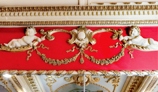 OLD AND NEW: Intricate wood detail fills the walls and ceiling inside the “Great Room” in the Gerald Hotel in Fairfield. The room will be furnished with contemporary items to be both functional and historical. Workers removed several layers of paint to reveal the original tangerine color.