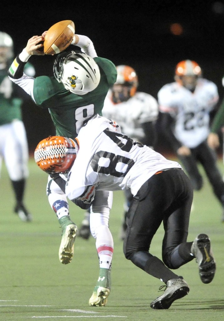 Staff photo by Michael G. Seamans CLASS C FOOTBALL:Winslow High School's Justin Martin, 84, hits Leavitt High School receiver Sam Green, 8, to break up the catch in the second quarter in the Class C state championship game at Fitzpatrick Stadium in Portland on Saturday. Leavitt defeated Winslow 47-18.