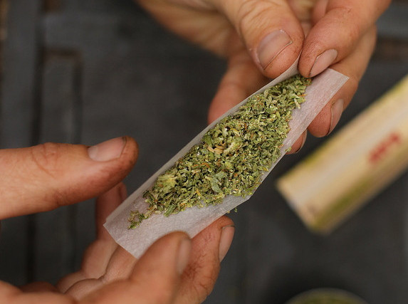 A smoker rolls a marijuana cigarette in Portland last month. The city’s electorate legalized recreational use of the drug last week, but federal and state laws still trump the local change.