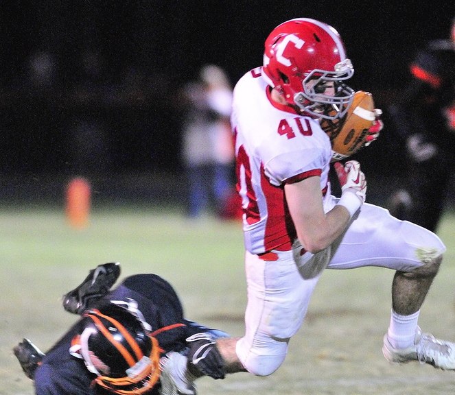 Staff photo by Joe Phelan Cony wide receiver Jonathan Saban is tripped up Brunswick's Pearson Cost, left during a game on Friday November 15, 2013 in Bath.