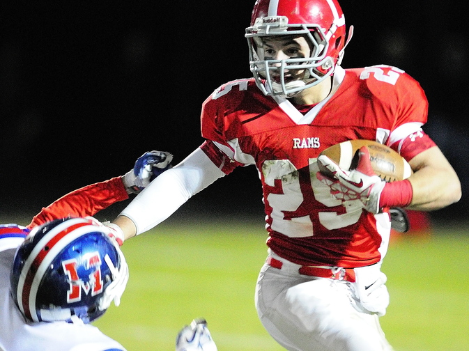 Staff photo by Joe Phelan Cony wide receiver Tayler Carrier, right, stiff arms a Messalonskee defender during a game on November 8, 2013 at Alumni Field in Augusta.