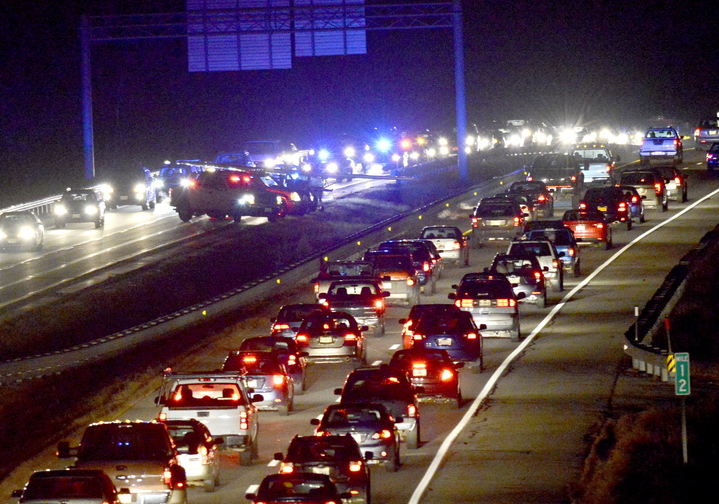 Cars drive past the small plane, upper left, that made an emergency landing Thursday on I-295. The landing backed up rush-hour traffic for miles in both directions on the interstate.