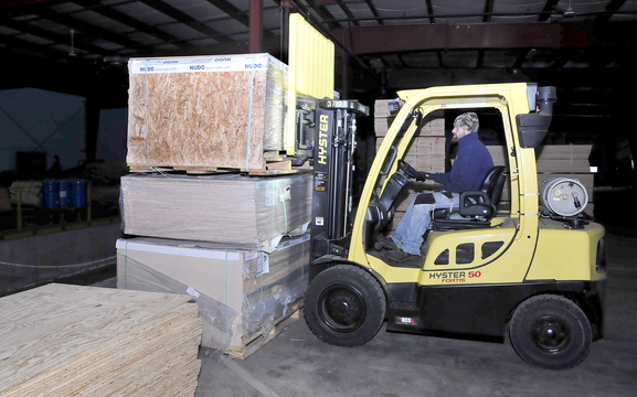 INCOMING: Cousineau Wood Products employee Ryan Atwood moves raw wood stock that now arrives by truck to the North Anson mill because Pan Am Railways no longer carries deliveries to the company.