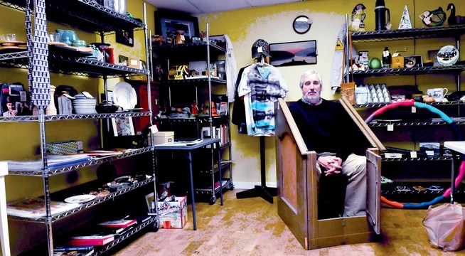 QUICK SALE: Iver Lofving sits inside an Anidrosis Box at his pop-up store in the Grist Mill in Skowhegan, where for two weeks he plans to sell a variety of unusual items. The box was used by locally by Dr. S.F. Conant in the 19th century. It is a sauna-like wooden crate used to help a person perspire. The person then was treated to a rubdown using an ointment of alcohol and opium to soothe ailments.