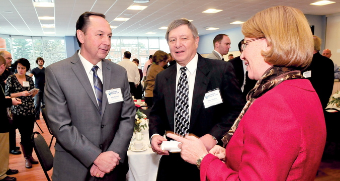GOT GAS: Mike Earnest, left, founder and CEO of Summit Utilities Inc., and Mike Minkos, president of Summit Natural Gas of Maine, speak on Tuesday with Beth Gibbs, of Thomas College, at the school in Waterville before updating legislators and other officials on the status of the pipeline construction project.