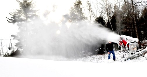 MAKING SNOW: Dave Beers, owner of Eaton Mountain in Skowhegan, adjusts one of the new snow guns that was making snow on the snow tubing hill on Wednesday. Beers said the facility will open this Saturday.