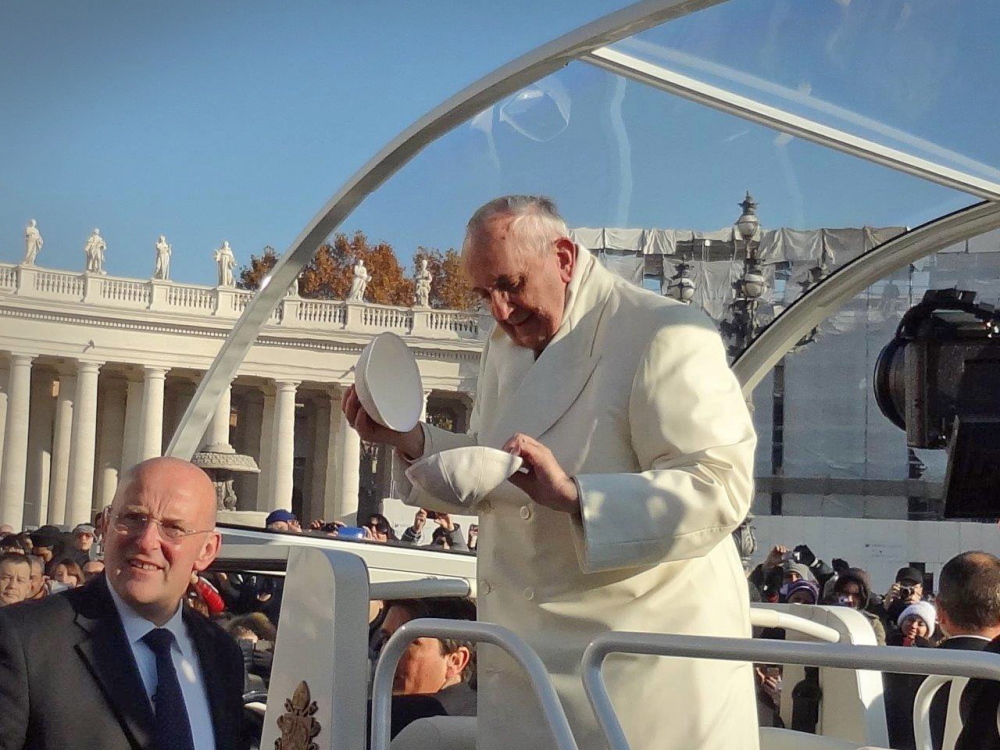 Pope Francis switches skullcaps in Rome on Wednesday after receiving a new one as a gift from Boston College exchange students Ethan Mack of Portland and Katherine Rich of Minnetonka, Minn. Pope Francis gave his skullcap to the students.