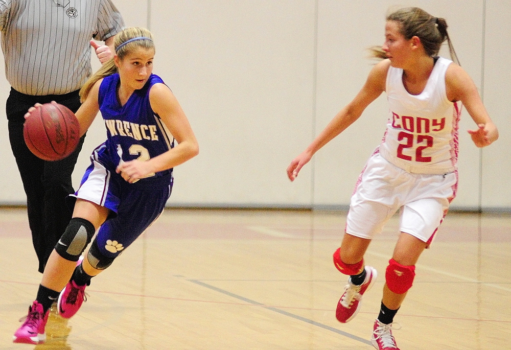 Staff photo by Joe Phelan Lawrence's Dominique Lewis, left, tries to drive past Conys Hayley Quirion on Friday December 13, 2013 during at game at Cony High School in Augusta.