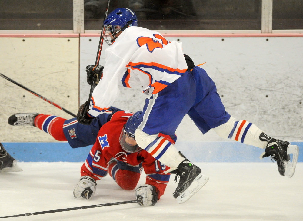 Messalonskee High School’s Dylan Brown, 15, collides with Lawrence/Skowhegan’s Chase Whittemore, 20, in the first period at Sukee Arena in Winslow on Wednesday.
