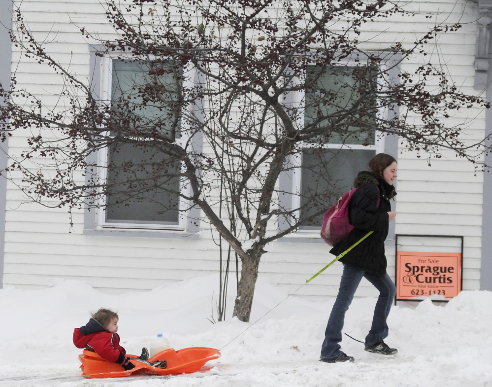 MILK RUN: Isaiah Jennings, 1, gets a tow Friday from his mother, Amanda, while returning from a shopping trip in Augusta. The couple bought milk before sliding up Northern Avenue to their home.