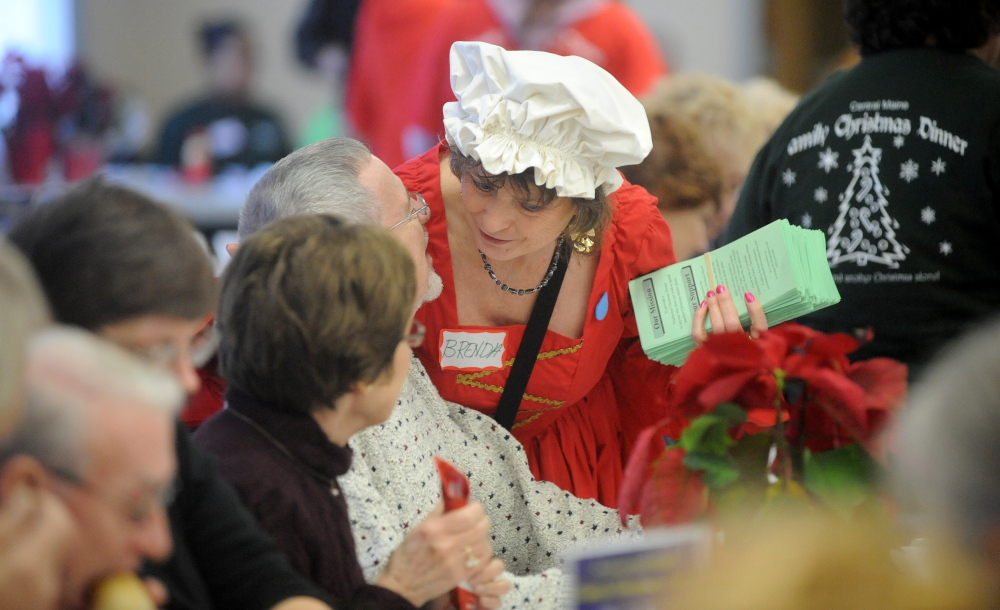 Staff photo by Michael G. Seamans CHRISTMAS IN WATERVILLE: Brenda Blair, a dinner volunteer, shares a moment with a patron of the 7th annual Central Maine Family Christmas Dinner at the Elk's Lodge in Waterville on Wednesday, Dec. 25, 2013. Organizers were expecting as many as 1000 diners this year.