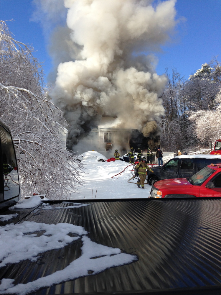 FIRE RESPONSE: Crews respond to a fire at Fire Road 14 in China Friday morning. Homeowner Neil Farrington saved his disabled brother-in-law from the blaze, but the home was a loss.