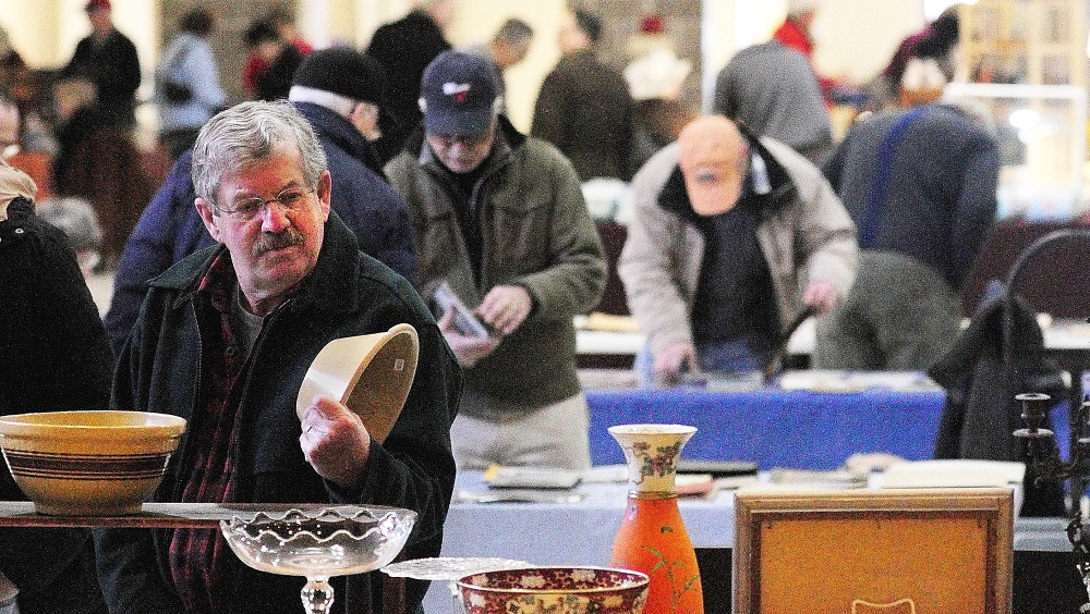 FORAGING: Dennis Ladd, of Farmingdale, looks at a bowl during the New Year’s Antiques Show on Wednesday at the Augusta State Armory.