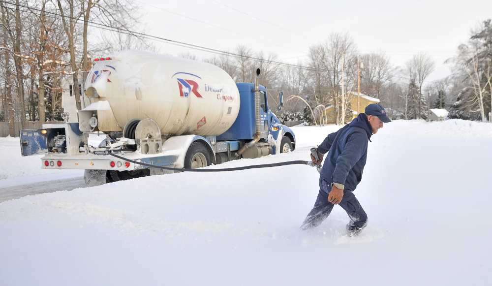 Staff photo by Michael G. Seamans WINTER HEAT: Greg French, a 15-year veteran delivery man for Dead River Oil, trudges through deep snow to make a delivery on Primrose Street in Winslow on Friday. French said it has been busier than usual compared to previous years. “We haven’t seen cold like this in a long time. Usually there is a bit of relief with a thaw. Not this year,” French said.