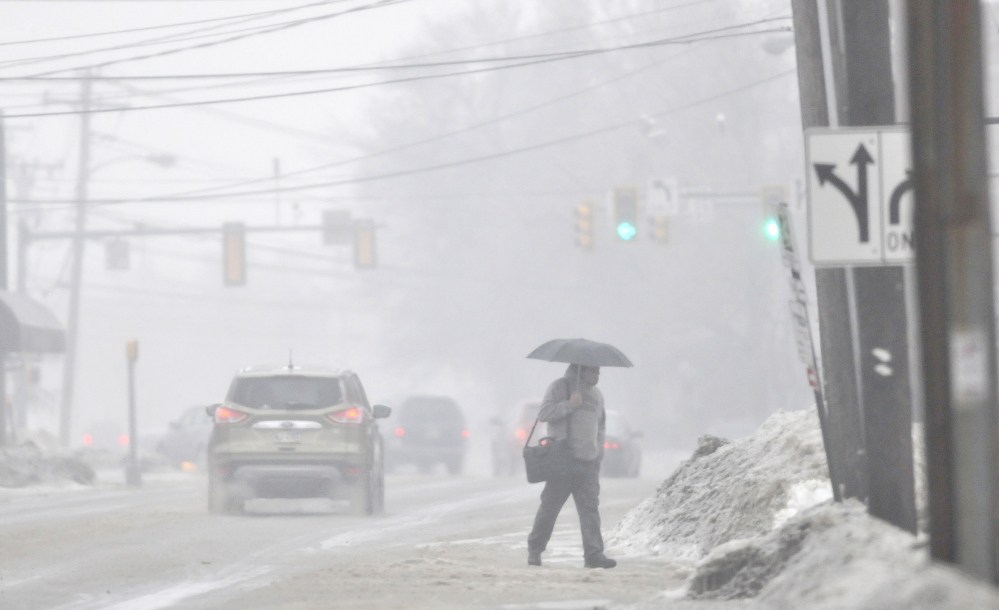 ICE walk: A pedestrian crosses Elm Street in Waterville on Saturday.