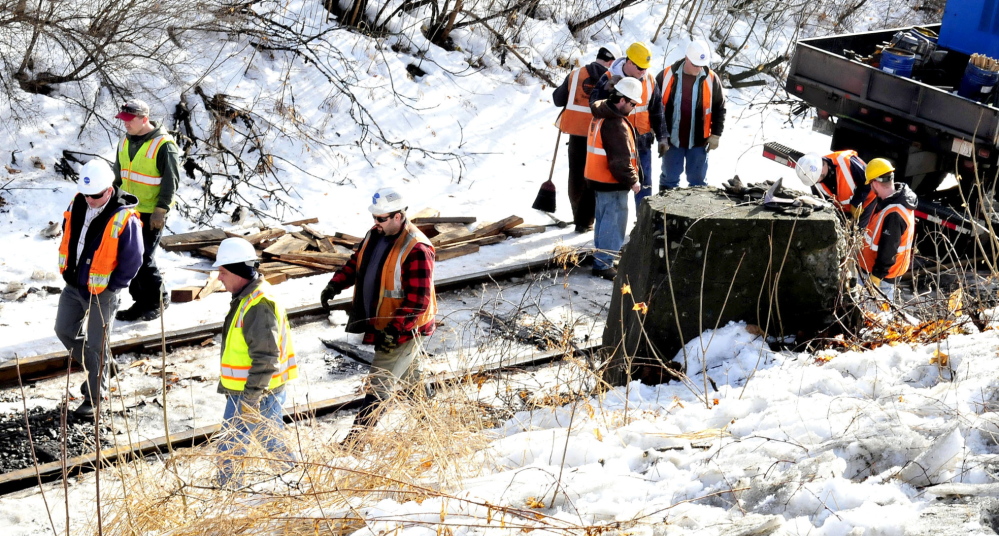 RAIL FIX: Workers with Pan Am Railways work on the twisted rail along Bay Street in Winslow on Wednesday. At least one railroad car has been listing to the side since Tuesday evening.