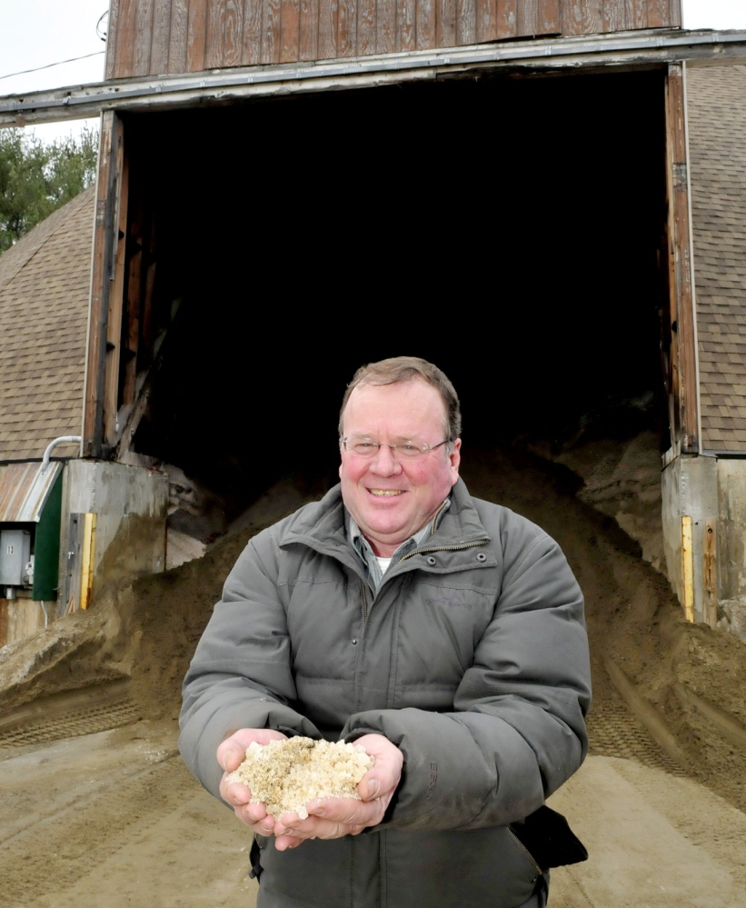 PASS THE SALT: Skowhegan Road Commissioner Greg Dore holds a handful of some of the salt that is mixed with sand at the town sand shed. Dore said without the use of salt the roads would be more dangerous for drivers and expensive for the town to maintain roadways.