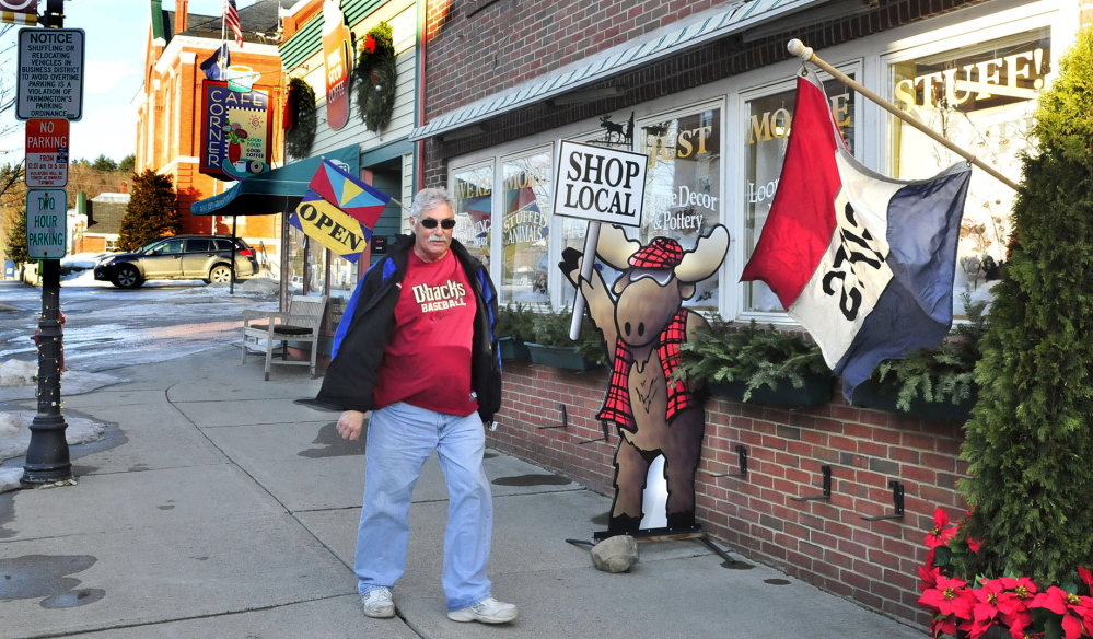 POPULAR SPOT: Chris Giemza walks past popular businesses Java Joes and Mooseville in downtown Farmington this week. Town officials are hoping new initiatives, including prochures and a proposed economic development committee, will bring new businesses and residents to town.