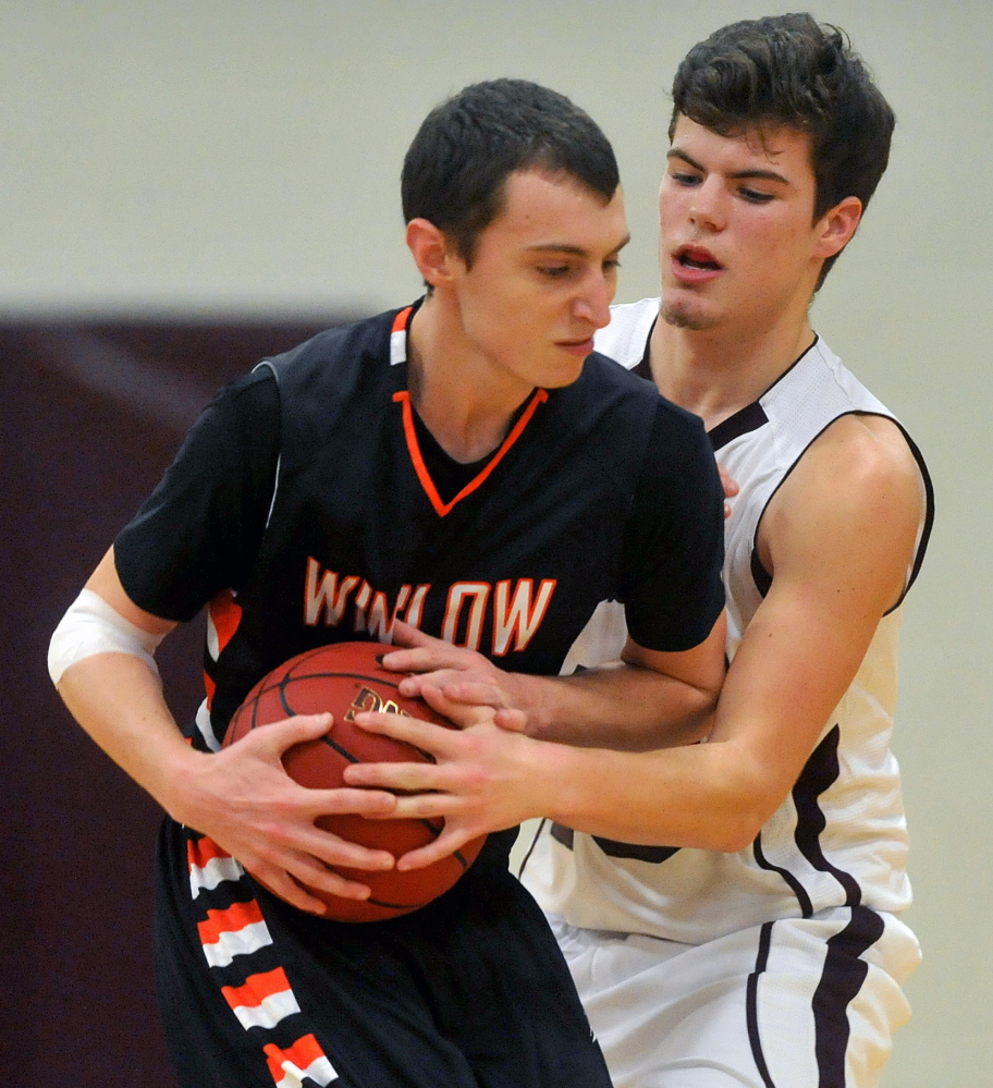 Staff photo by Michael G. Seamans Maine Central Institute's Jordan Valente, 10, right, fouls Winslow High School's Trevor Lovely, 3, in the second quarter in Pittsfield on Friday.