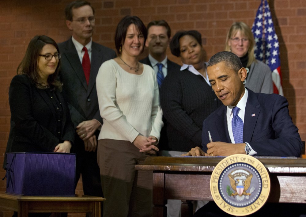 President Barack Obama signs the $1.1 trillion spending bill that funds the federal government through the end of September, in Washington on Friday.