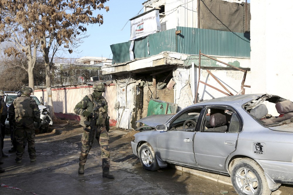 NATO International security assistance forces personnel investigate at the site of the Friday’s suicide attack and shooting, in Kabul, Afghanistan, on Saturday. A Taliban suicide bomber and two gunmen on Friday attacked a Lebanese restaurant that is popular with foreigners and affluent Afghans in Kabul, a brazen attack that left 16 dead, including foreigners dining inside and two other gunmen, officials said.