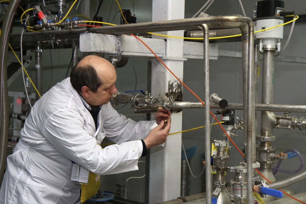 An unidentified International Atomic Energy Agency inspector cuts the connections between centrifuge cascades at the Natanz facility, some 200 miles south of Tehran, Iran, on Monday.