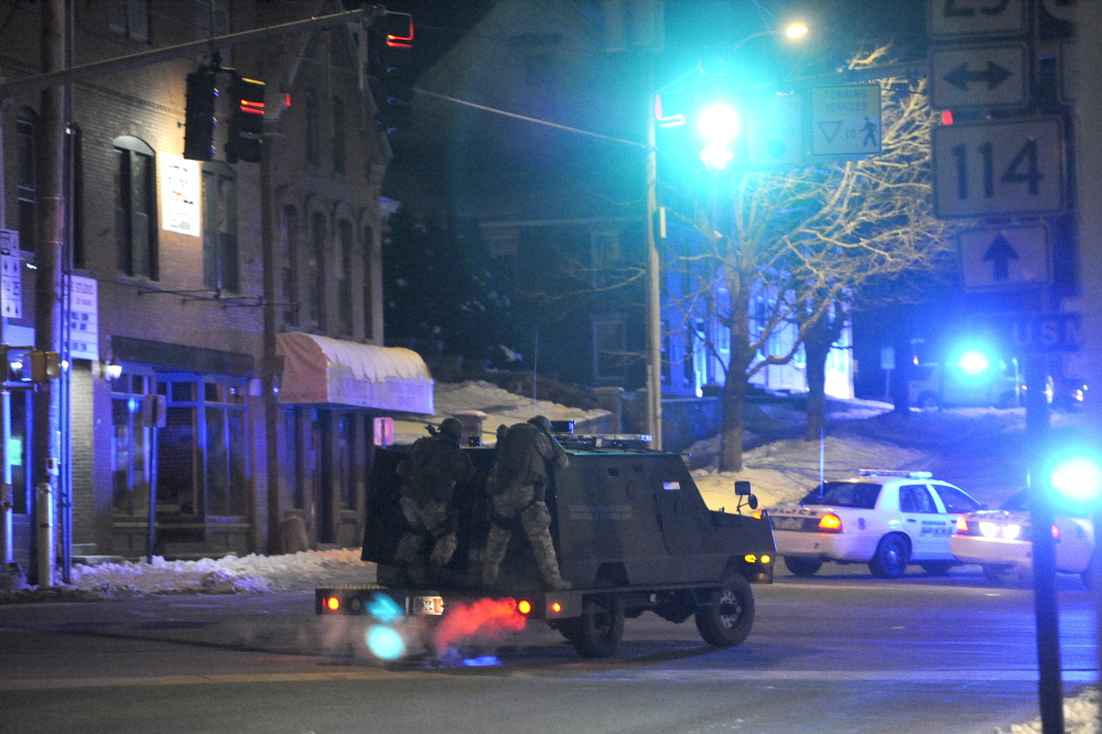 A Cumberland County Sheriff’s Office armored vehicle with two SWAT members on the back turns from Route 114 onto Route 25 in Gorham near the site of a police standoff with a gunman.