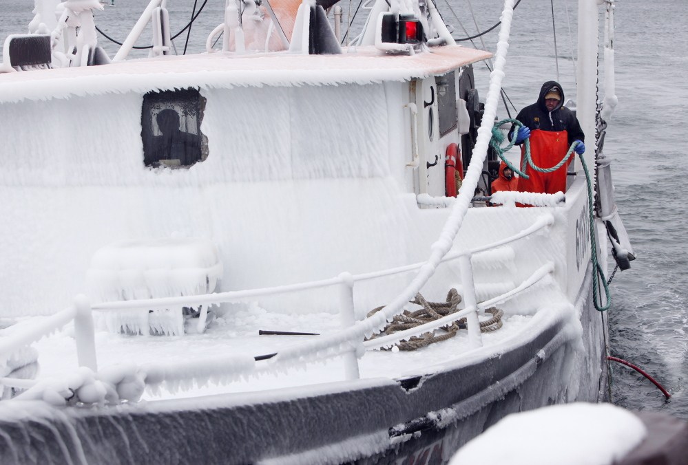 On the side of an iced-over wheelhouse, Larry Rich of Portland prepares to throw a line as the Black Beauty approaches a dock on the Portland waterfront Wednesday morning after returning from an overnight fishing trip.