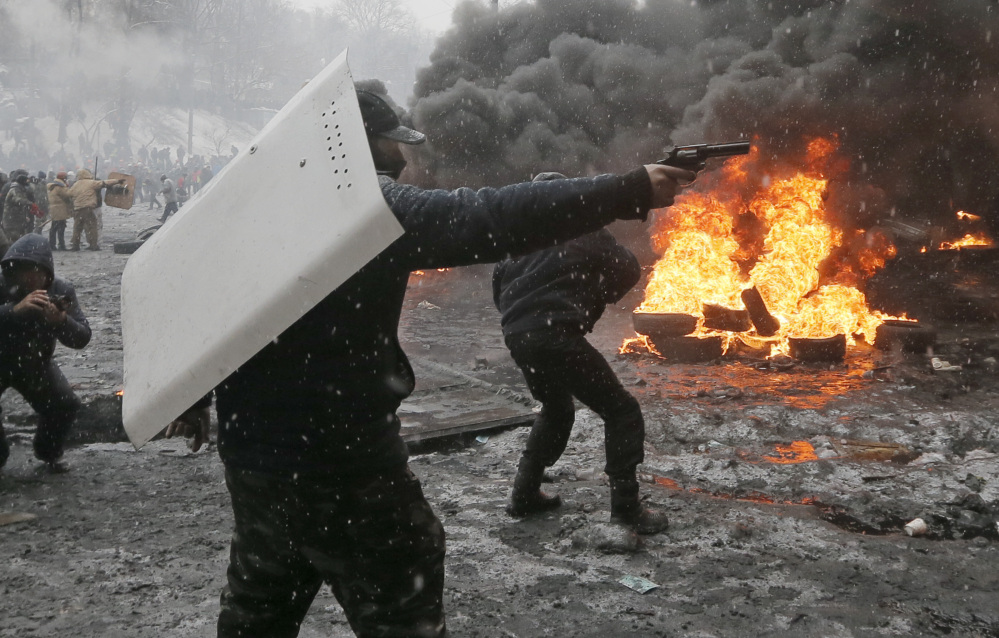 A protester points a handgun during a clash with police in central Kiev, Ukraine, Wednesday.