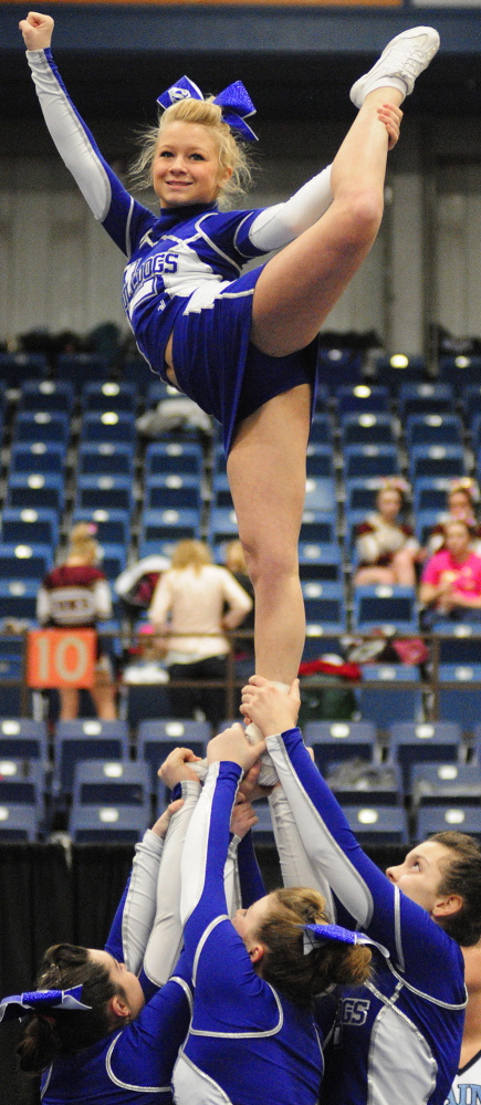 Staff photo by Joe Phelan Flyer Danielle Auge is held aloft by her Lawrence teammates as the Bulldogs compete in the Class A East cheering championship on Saturday January 25, 2014 in the Augusta Civic Center.